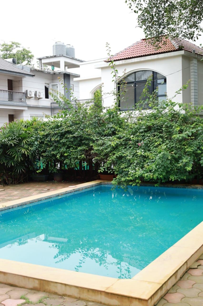 Anjuna Abode 1 — shared swimming pool with lush garden